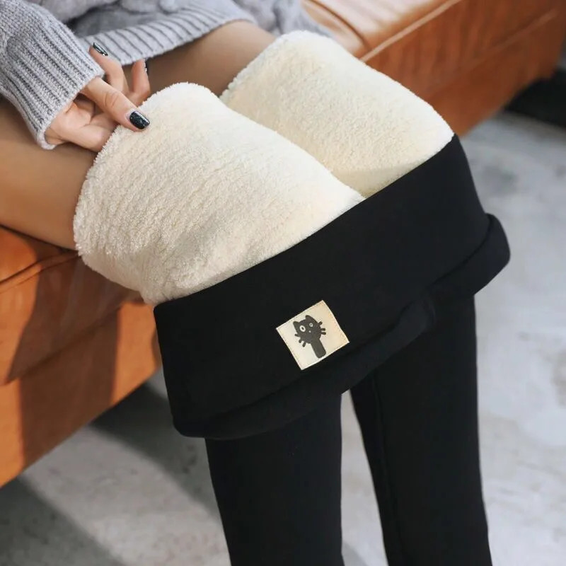 Black fleece-lined high-waist leggings folded to show the cream velvet-fleece lining and waistband badge